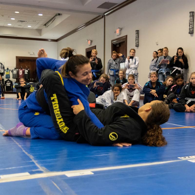 Photo of Rachel Casias demonstrating a Brazilian Jiu-Jitsu move at Roll Model Women's Only Grappling Camp